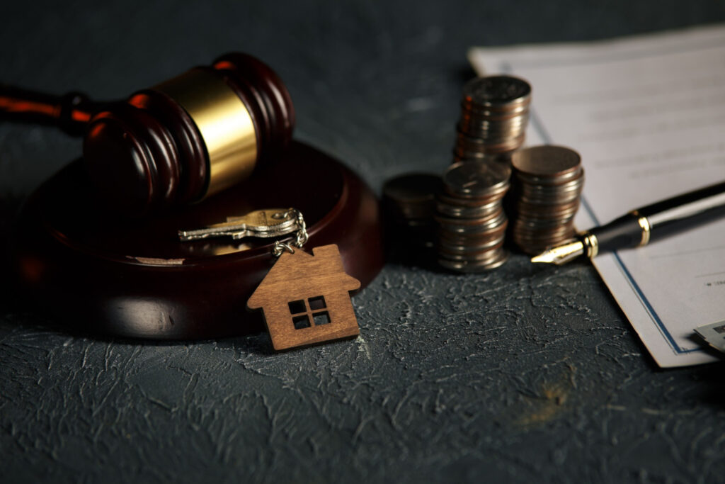 Miniature house with money and tax papers