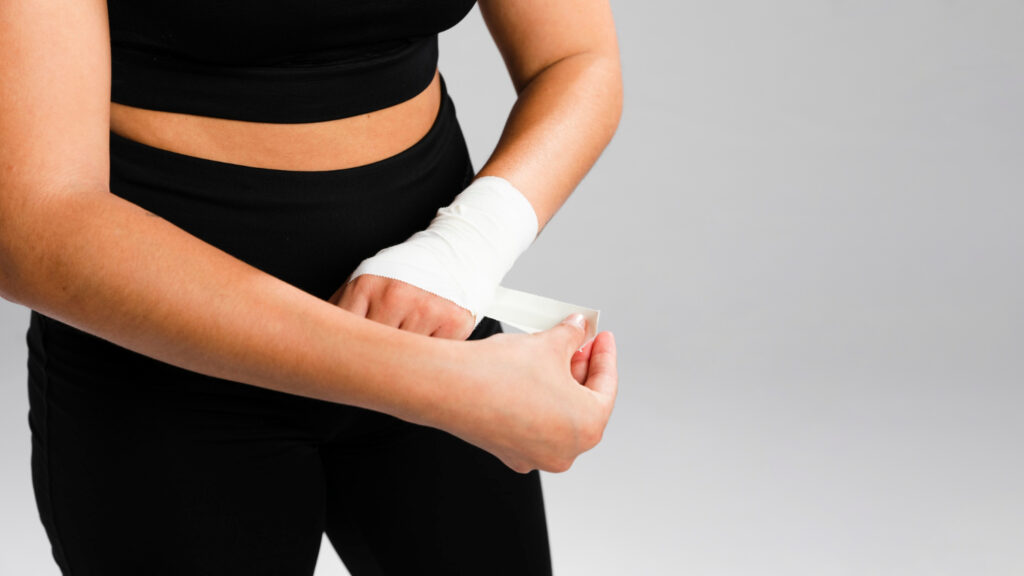 Woman bandaging her hands