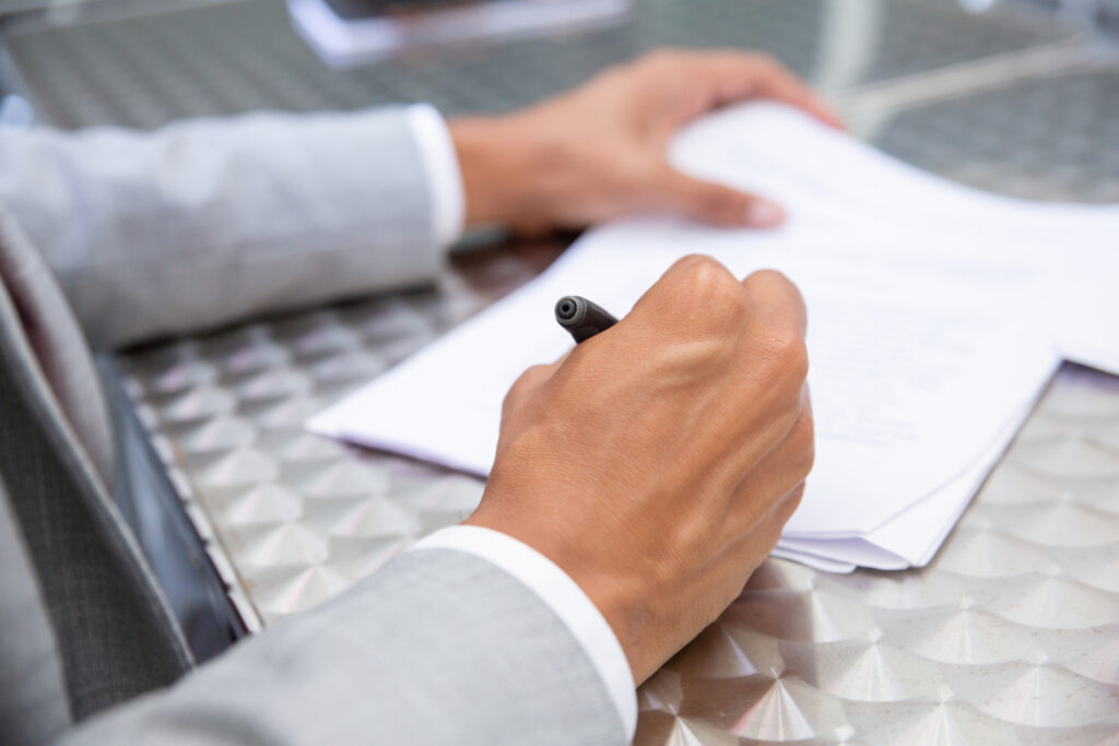 Male hand signing paper