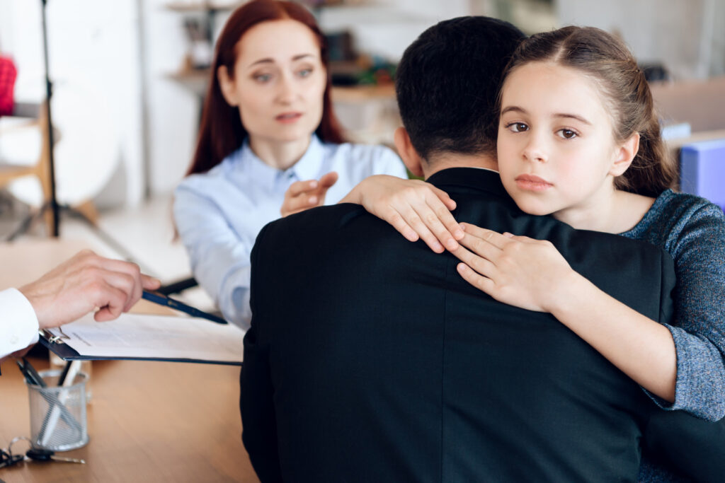 Little girl hugs man in suit